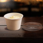 Compostable cup with lid on a wooden surface