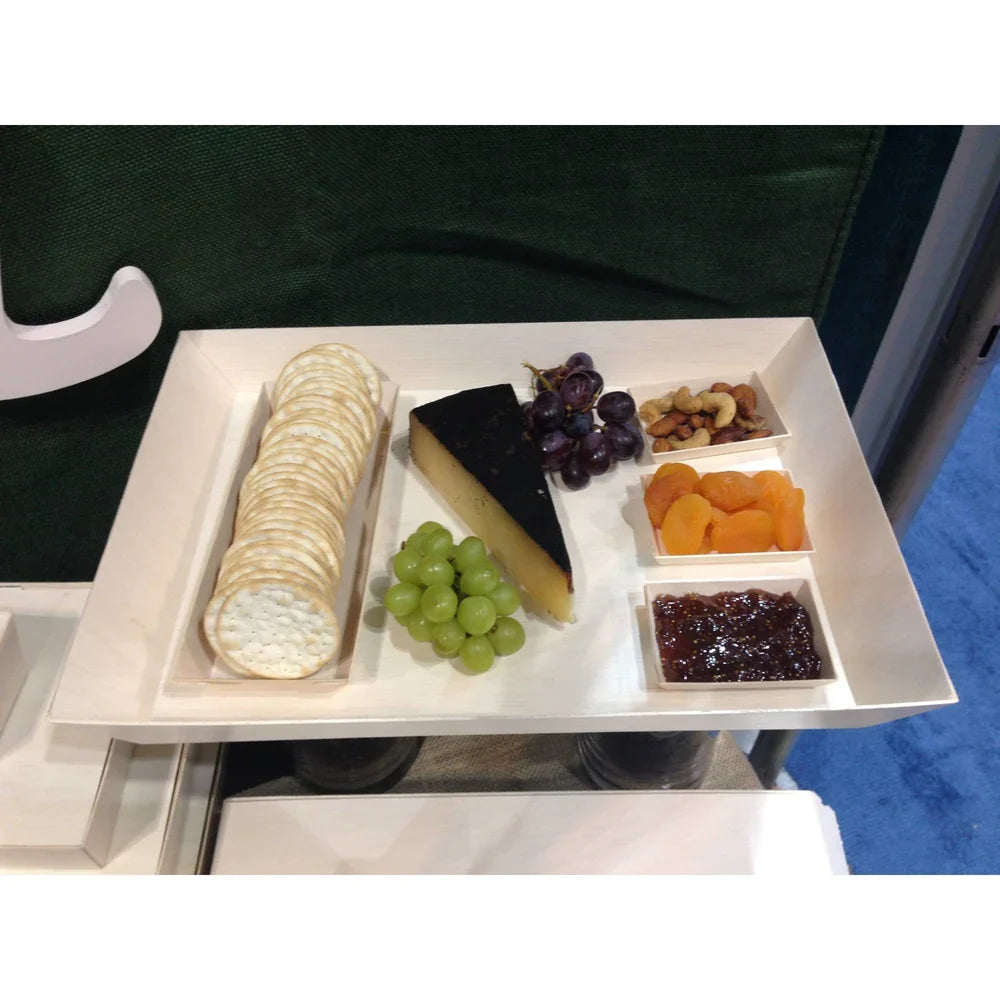Assorted food items including crackers, cheese, grapes, nuts, and dried fruits on a balsa wood tray.
