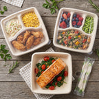 Three meal prep containers with various foods on a wooden surface.