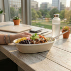 Fiber bowl of salad on a table with a cityscape view
