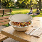 Bowl of food with a lid on a wooden table in a park setting