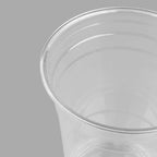 Close up of rim of clear plastic cup on a gray background
