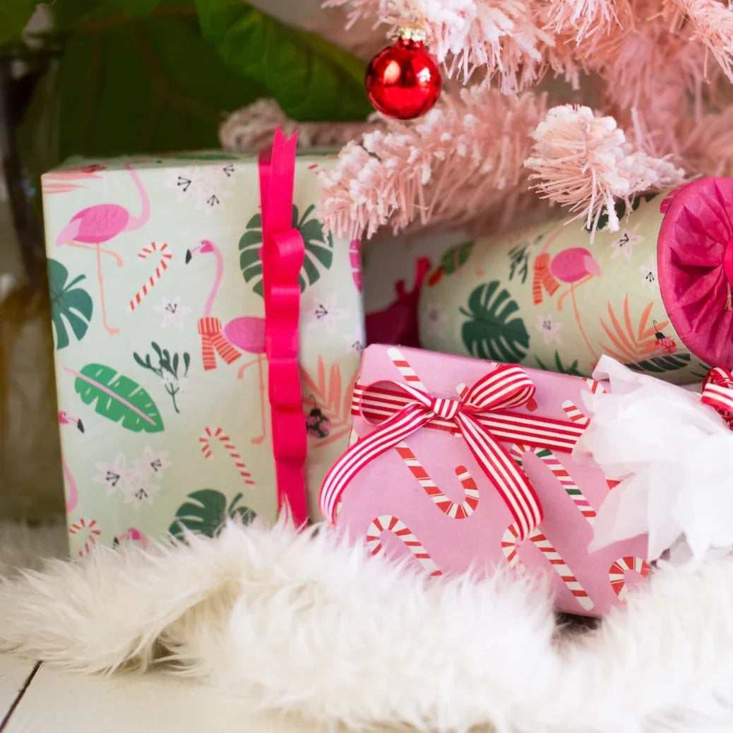 Gifts wrapped in eco-friendly paper with pink ribbon and red/white strip ribbon.