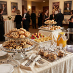 Dessert table with cookies, pastries, and drinks decorated with piano ribbon at a formal event.
