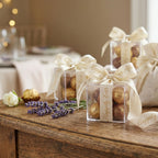 Decorative boxes with gold balls and cream wedding ribbons on a wooden surface with blurred background