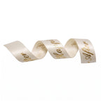 Cream ribbon with gold text on a white background