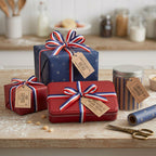 Gift boxes with red, white, and blue ribbons on a wooden surface.