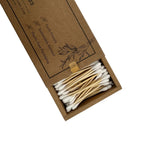 A box of reusable bamboo cotton swabs shown open on a white background, with the kraft-paper packaging and the white-tipped swabs arranged in the compartment.