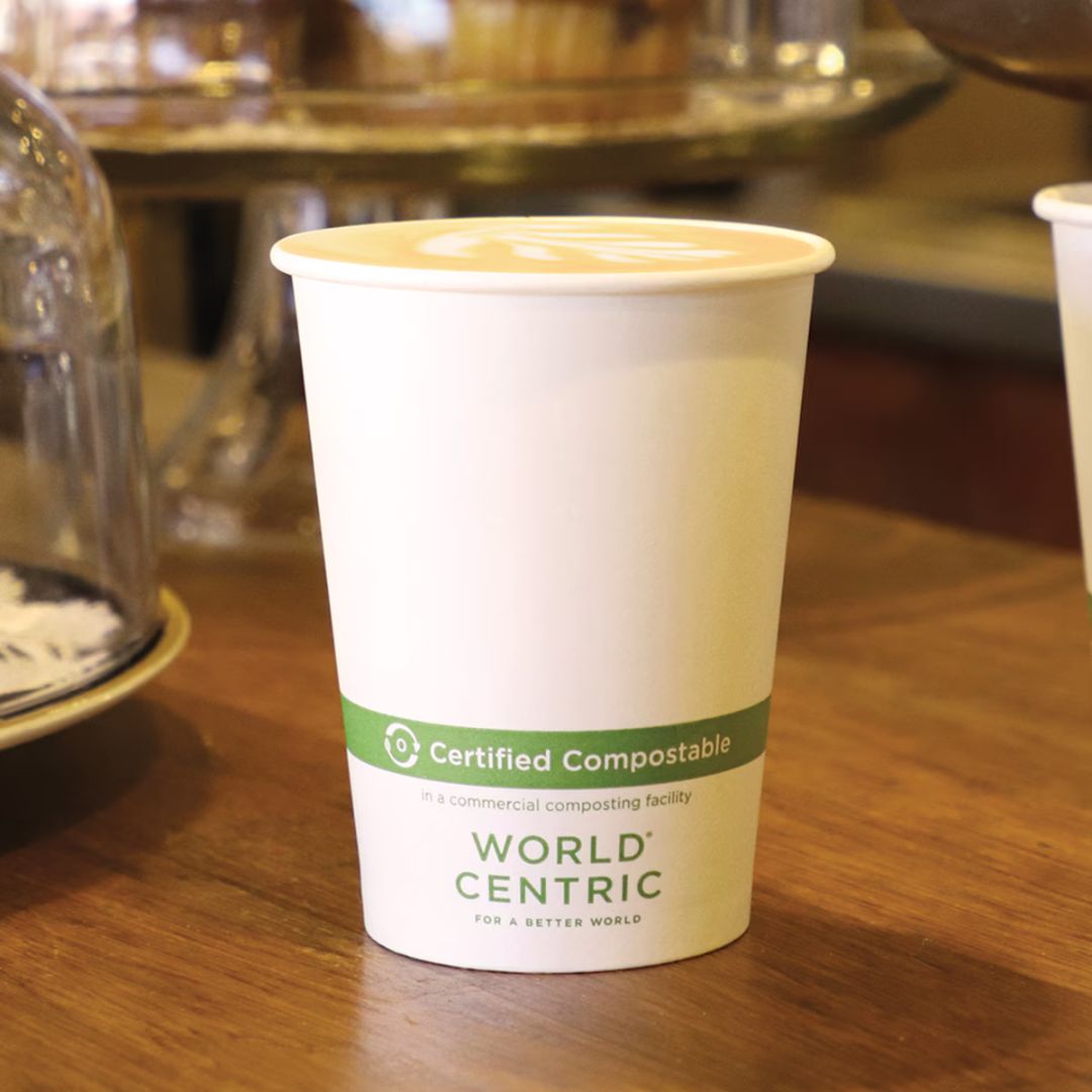 Compostable coffee cup with World Centric label on a wooden table