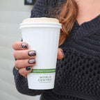 Person holding a World Centric compostable coffee cup