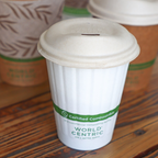 Compostable double wall hot cup with a fiber hot cup lid resting on a wooden table.