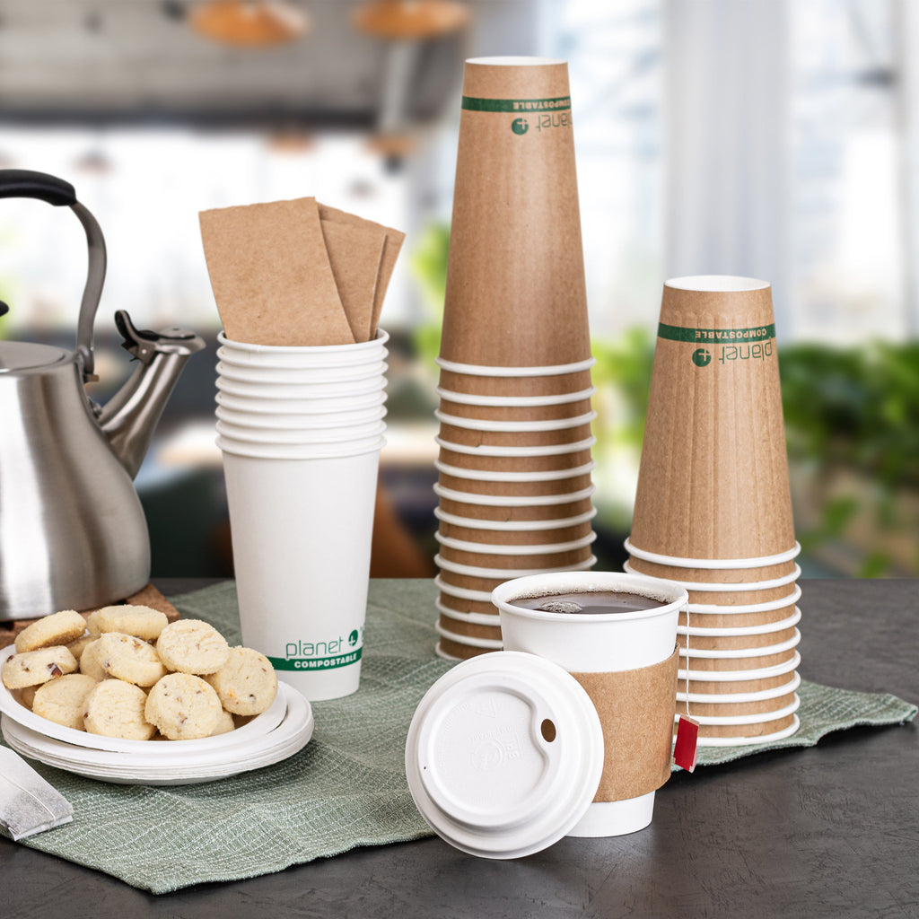 Stacks of paper cups with a kettle and cookies on a table