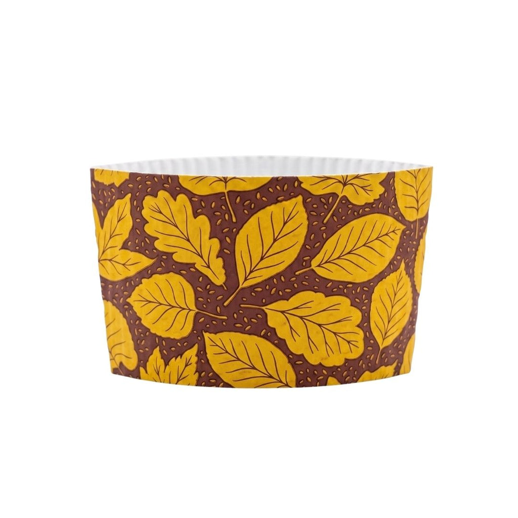 A fall paper cup sleeve featuring a pattern of yellow oak leaves on a dark brown background with small white dots, shown on a plain white background.