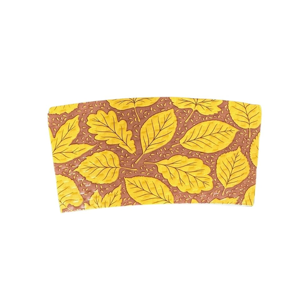 A compostable hot cup sleeve featuring a gold leaf pattern on a brown background, shown against a plain white backdrop.