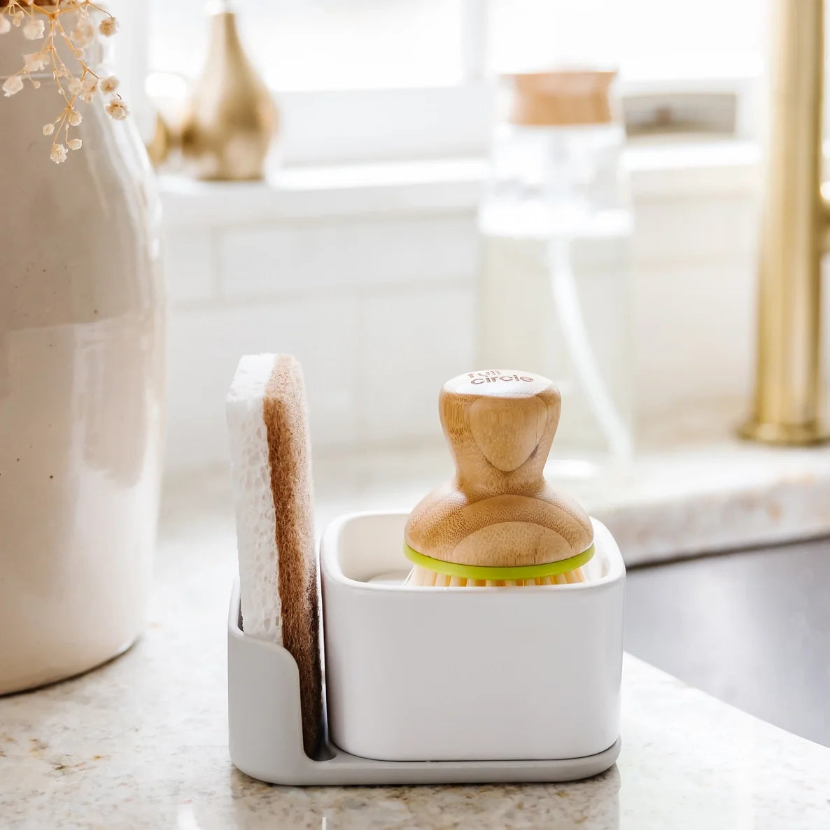 Kitchen cleaning set with scrubber sponge and brush holder on a kitchen counter.