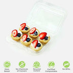Small dessert bites with berries in a clear dessert container on a white background