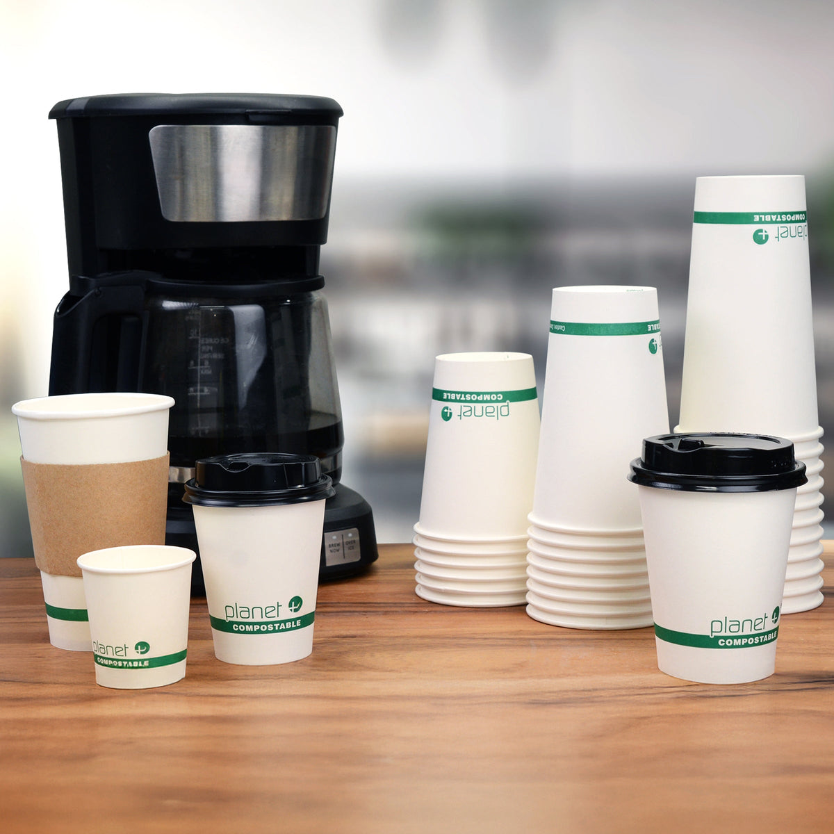 Coffee machine with compostable cups on a wooden surface