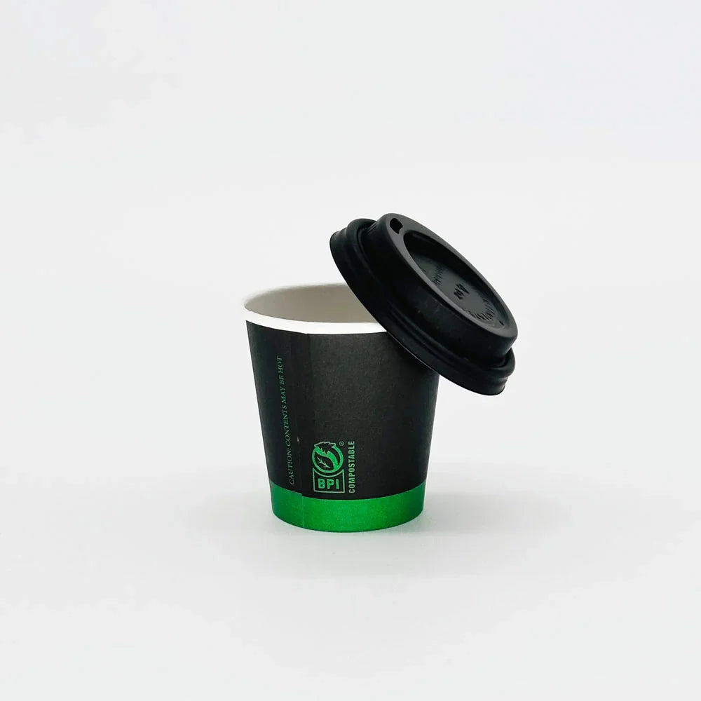 Black paper cup with a green logo and black lid on a white background