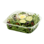 Salad in a clear plastic container with a lid on a white background