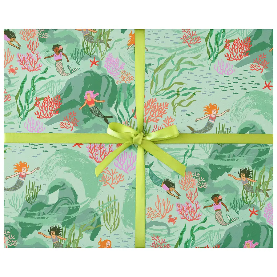 Wrapping paper with a mermaid and coral ocean-themed print, tied with a bright yellow-green ribbon and bow in the center.