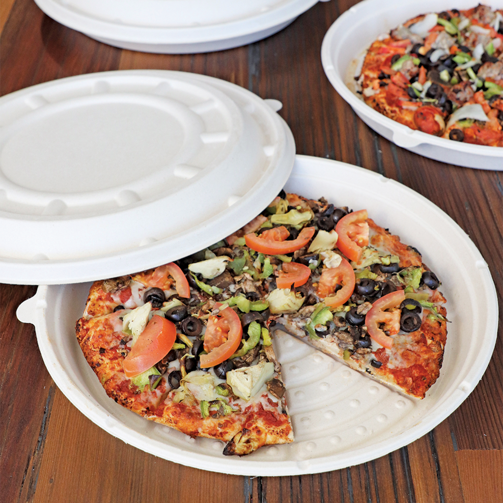 Pizza in a disposable round pizza tray with a lid on wooden table.