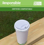 White compostable cup with lid on a wooden surface, green background