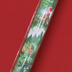 Close up view of Bigfoot gift wrap featuring forest scenes on a plain red background.