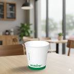 White paper cup with 'ecotainer' logo on a wooden table in a blurred cafe setting