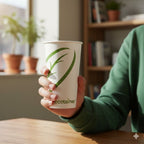 Person holding a paper cup with 'ecotainer' branding in a home setting.