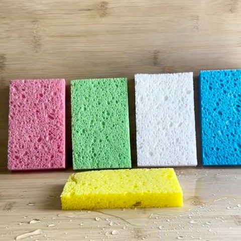 Five colorful sponges on a wooden surface
