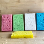 Five colorful sponges on a wooden surface