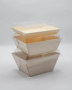 Stack of disposable food trays with lids on a light gray background
