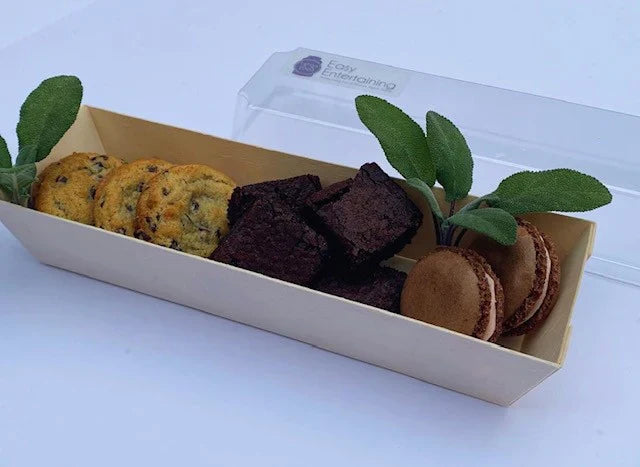 Box of assorted cookies with a clear lid on a white background