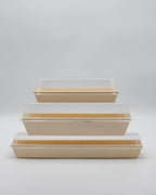 Set of three rectangular boxes with clear lids on a light gray background