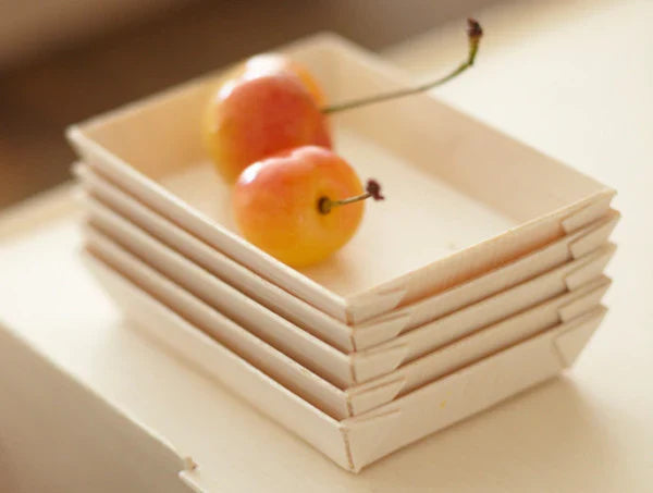 Stack of mini compostable balsa wood appetizer trays.