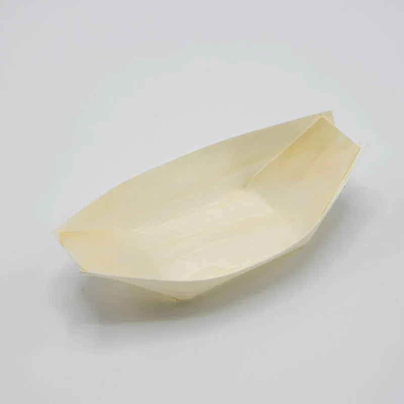 A small, boat-shaped paper food tray made of light-colored paper, photographed on a neutral light gray background.