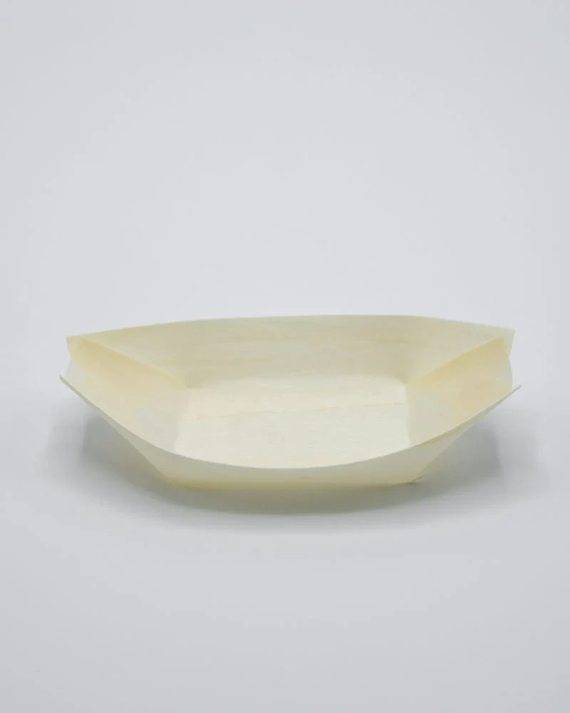 A single pale cream paper boat-shaped tray or plate photographed on a clean light gray studio background.