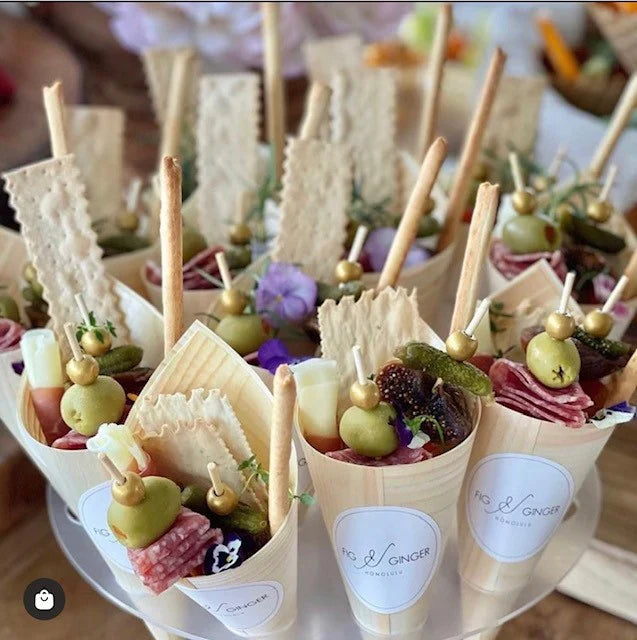 Cones filled with charcuterie foods at a catered event.
