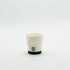 White paper cup with a green rim on a white background