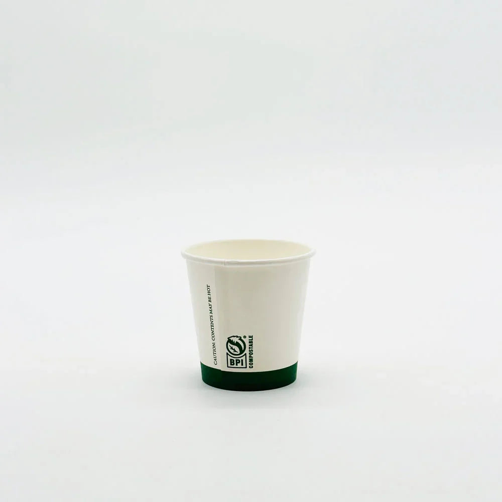 White paper cup with a green rim on a white background