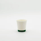 Compostable hot cup with green rim on a white background