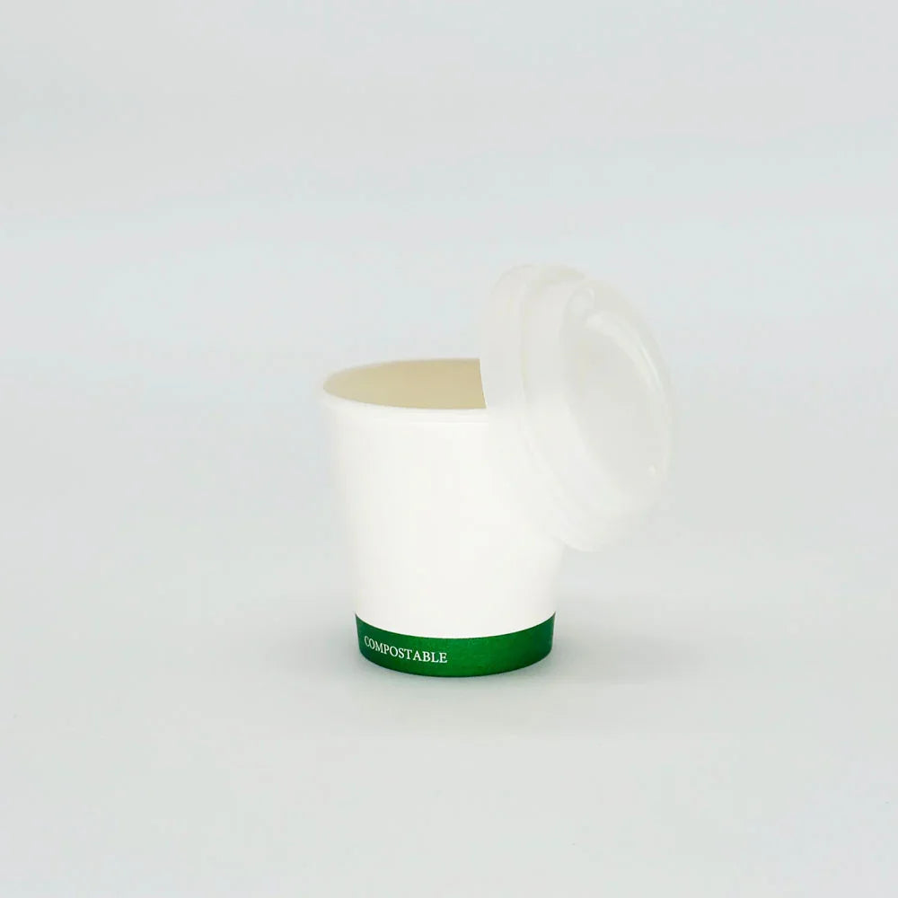 Green label hot cup with a lid on a white background