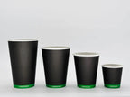 Set of four black paper cups with green labels on a white background