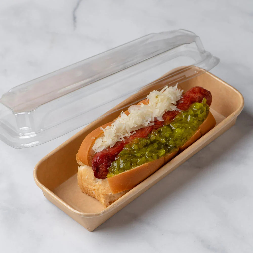 Hot dog with sauerkraut and relish in a paper tray on a marble surface