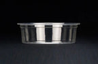 A clear portion cup on a dark textured surface against a black background.