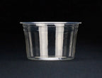 A compostable cup with a flat rim, photographed against a solid black background.