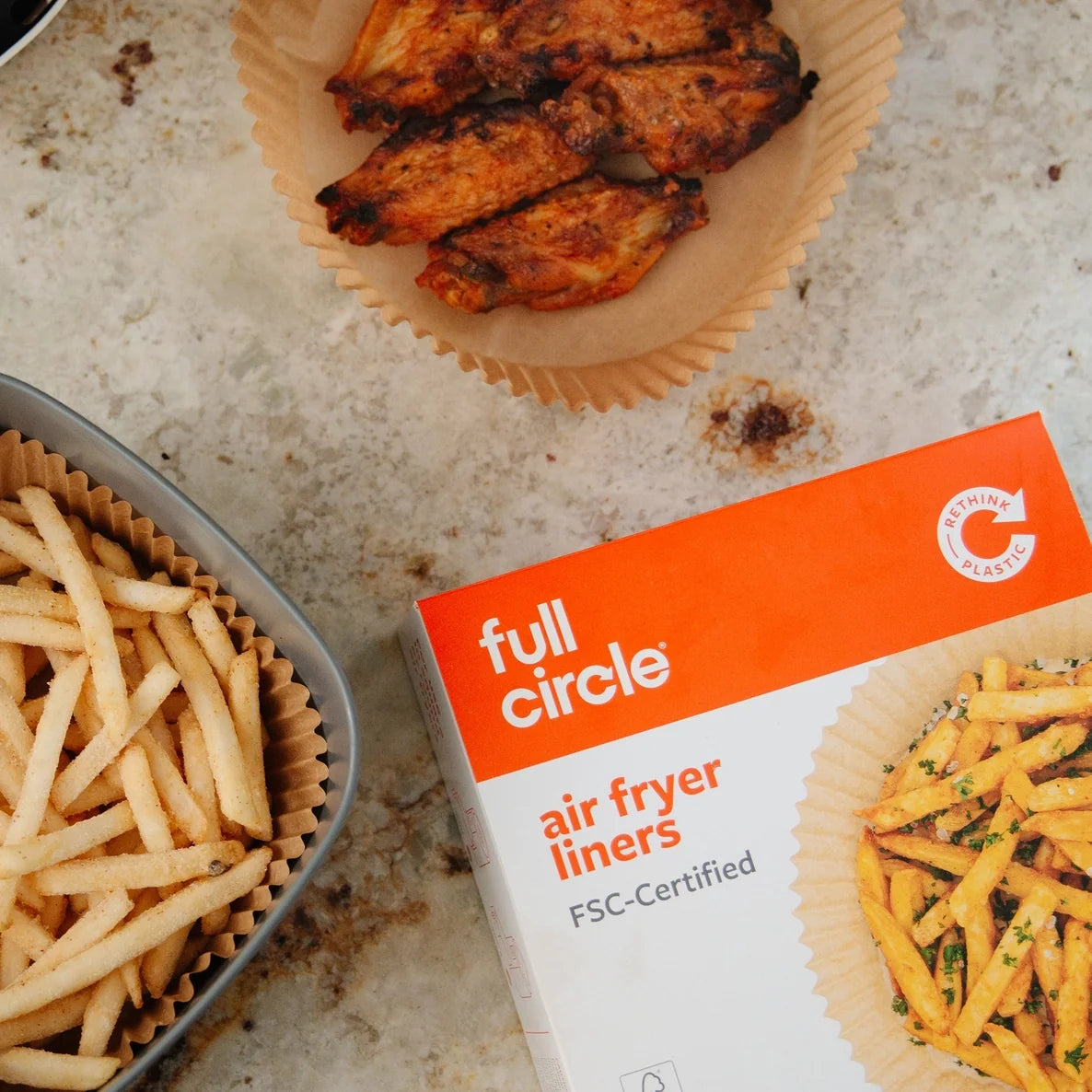 Box of full circle air fryer liners with air fried food on a countertop