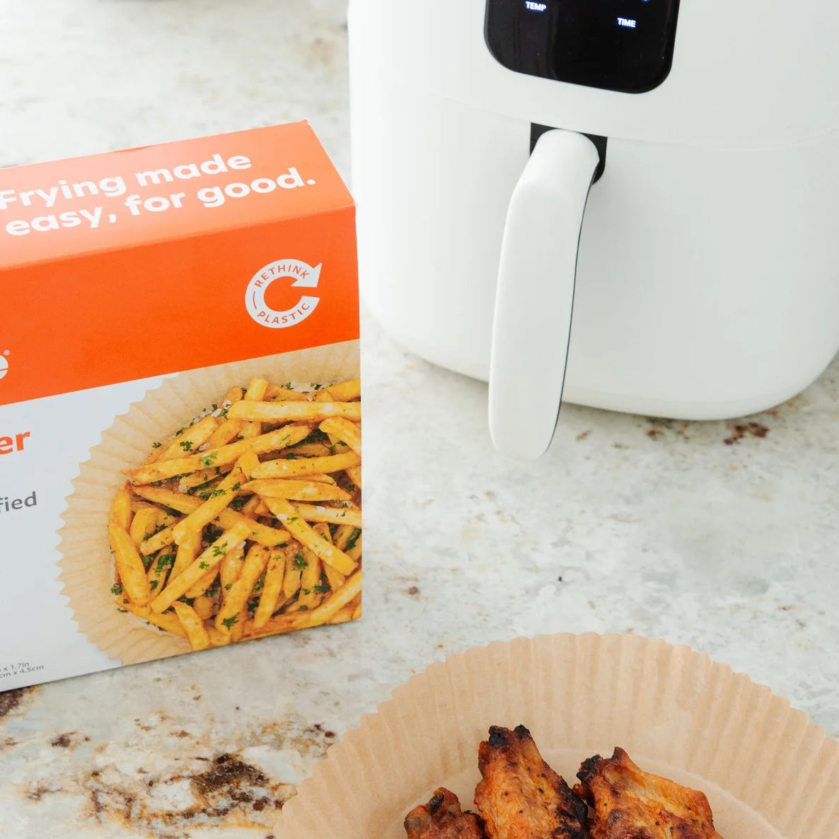 White air fryer with a box of full circle air fryer liners on a countertop.