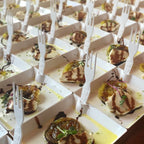 Small food portions on white small plates with plastic forks, arranged in rows.