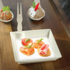 Small appetizer plate with appetizers on a wooden table